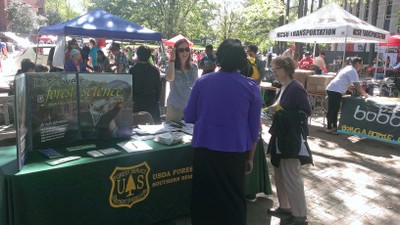 Earth Fair attendees talk at a display table